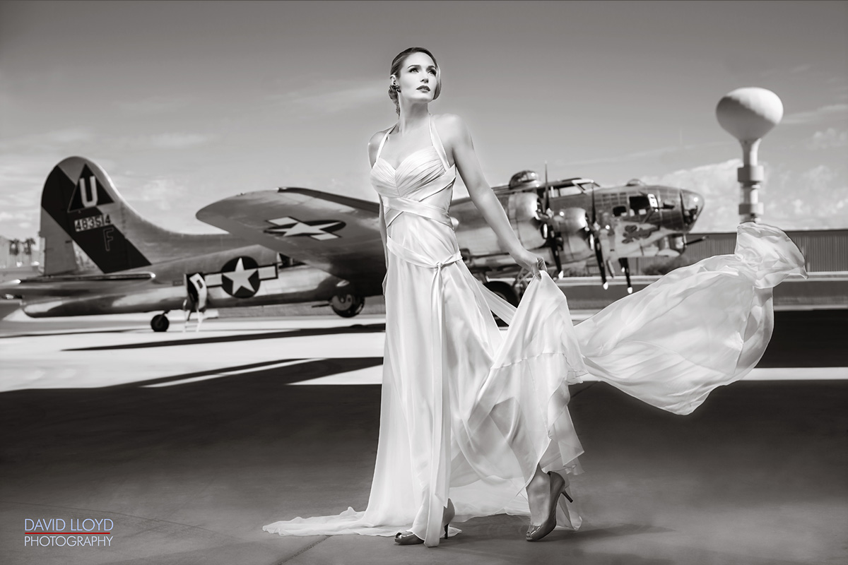 black and white woman standing in front of military planes outside with white dress, fashion, fashion photography, glamour photography