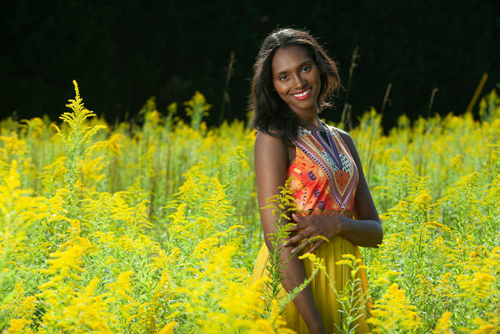 Model in bright dress poses in field for photography class, model photography in nature, portrait photography, model poses, photography pose, nature photographer