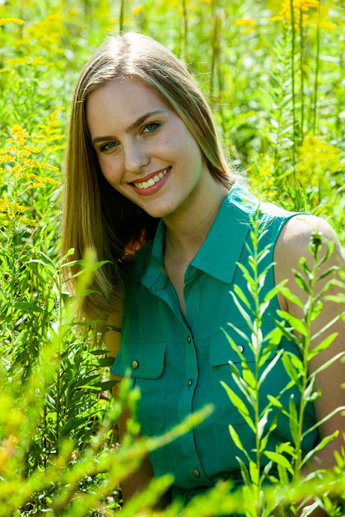 Model with turquoise smiles in field, model photography in nature, portrait photography, model poses, photography pose, photography class, Atlanta portrait photographer