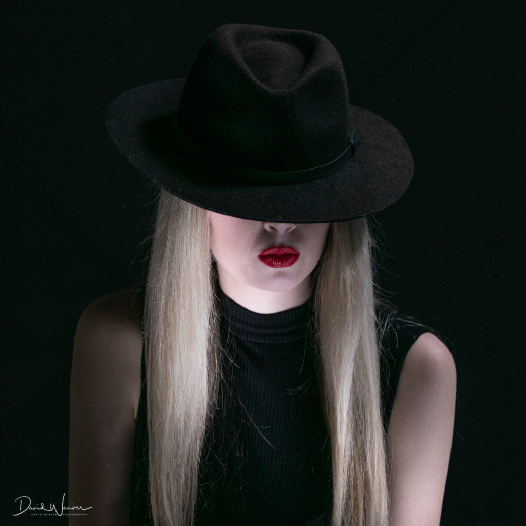 Model covers eyes with black top hat, portrait photography, fisheye connect, photography workshop, model workshop, studio workshop, photography studio, studio lighting, photoplex studios, lighting skills, portrait photography workshop, fisheye connect workshops, model poses, workshop with models