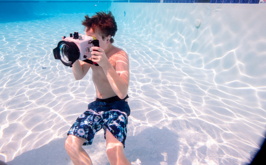 boy taking underwater photograph